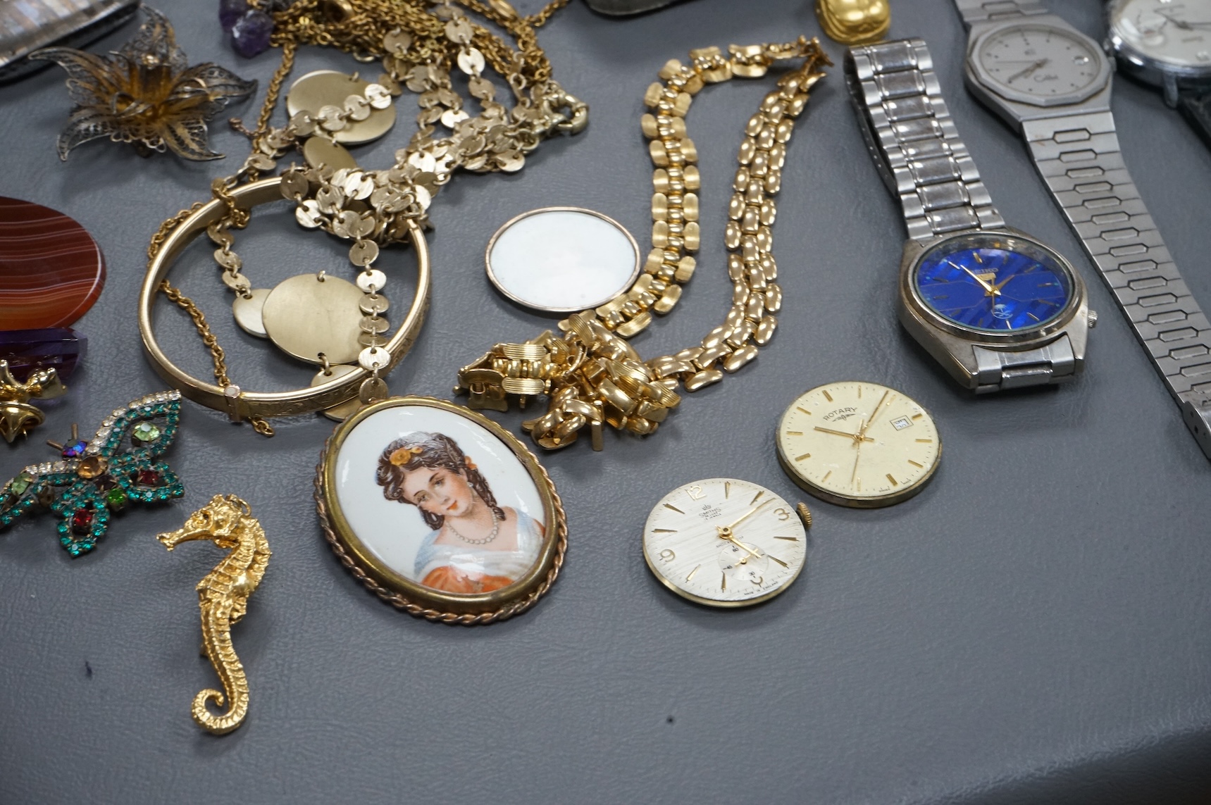 A quantity of assorted costume jewellery and other items including wrist watches, watch movements and a silver vesta case.